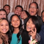 A group of adults smiling to take a photo at the photo booth