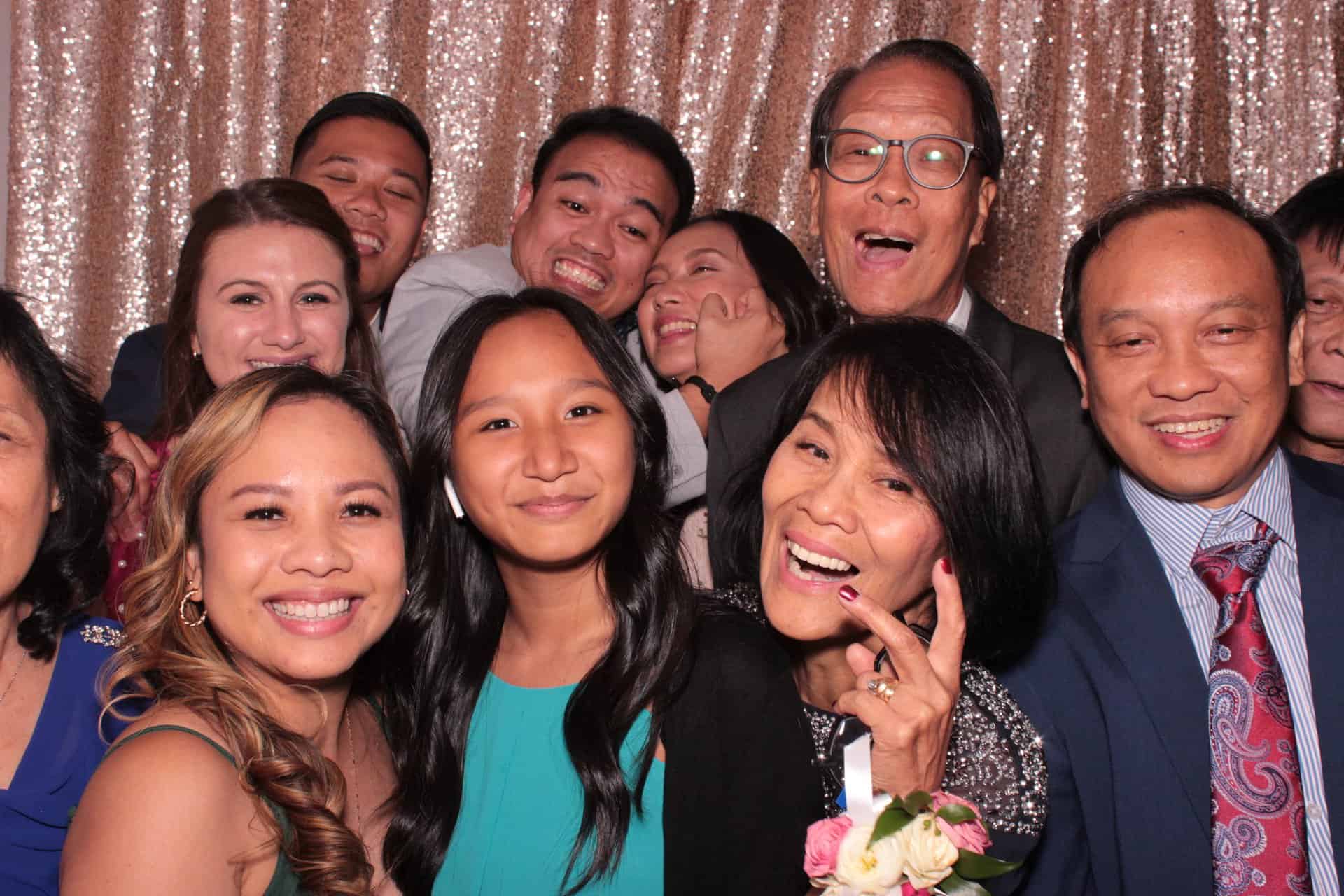 A group of adults smiling to take a photo at the photo booth