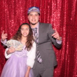 using prop money, two people flashing benjamins inside a photobooth