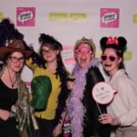 Photo booth used during a corporate event depicting 4 women smiling and holding props