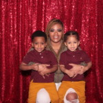 Mom with two children taking a photo in the photo booth
